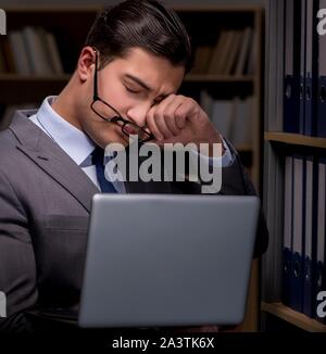 Imprenditore quasi addormentarsi a lavorare fino a tardi in ufficio Foto Stock