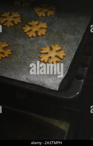 Per ottenere gingerbread cookie sotto forma di fiocchi di neve da una presina. Foto Stock