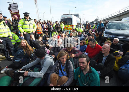 I dimostranti bloccando la strada al di fuori della città Aeroporto, London, durante una ribellione di estinzione il cambiamento climatico protesta. Foto Stock