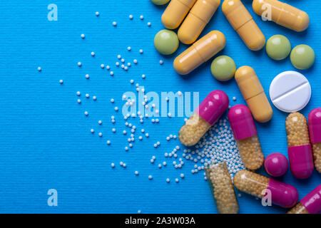 Vista da sopra con il bianco pillole e capsule di colore giallo e viola e verde pillole. Spazio di copia e la macro Foto Stock