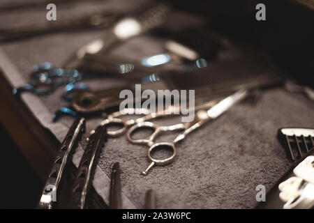 Strumento di barbiere in barberia. Parrucchiere attrezzo. Forbici, pettini, rasoi, Clippers. Strumento per la procedura guidata. Organizzazione dei luoghi di lavoro. Messa a fuoco selettiva Foto Stock