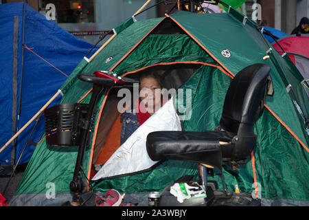 Londra, Regno Unito. Il 9 ottobre 2019. Estinzione della ribellione protester con il suo scooter di mobilità al di fuori la sua tenda, visto nelle prime ore del mattino durante le due settimane di protesta a lungo a Londra. Credito: Joe Kuis / Alamy News Foto Stock