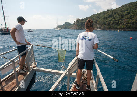 Servizio di pulizia del mare, in accordo con la onlus guardia costiera ausiliaria, un'apposita imbarcazione raccoglie i rifiuti galleggianti, li sbarc Foto Stock