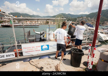 Servizio di pulizia del mare, in accordo con la onlus guardia costiera ausiliaria, un'apposita imbarcazione raccoglie i rifiuti galleggianti, li sbarc Foto Stock