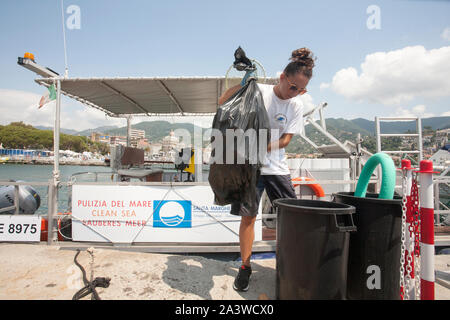 Servizio di pulizia del mare, in accordo con la onlus guardia costiera ausiliaria, un'apposita imbarcazione raccoglie i rifiuti galleggianti, li sbarc Foto Stock