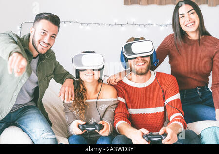 Felice millennial amici per giocare con i videogiochi con la realtà virtuale cuffie - i giovani si divertono con il nuovo vr online tecnologia trend Foto Stock