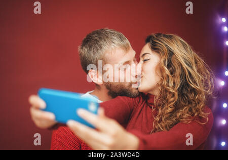 Coppia felice facendo una selfie con smartphone mobile app - giovani amanti avendo divertimento prendendo selfie con la fotocamera del telefono Foto Stock