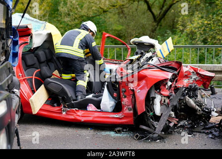 Il 10 ottobre 2019, Baden-Wuerttemberg, Schwäbisch Gmünd: Vigili del Fuoco fissano un incidente sul sito di Bundesstraße 29. Una femmina di auto conducente morto sulla Bundesstraße 29 in Ostalbkreis in una collisione con un carrello. Foto: Sven Kohls/SDMG/dpa Foto Stock