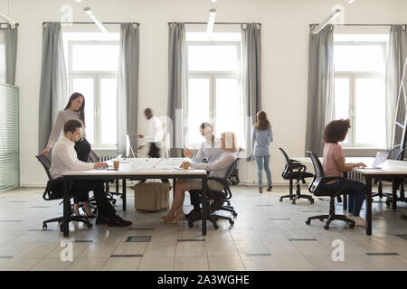 Occupato diversi dipendenti che lavorano in ufficio moderno sala coworking Foto Stock