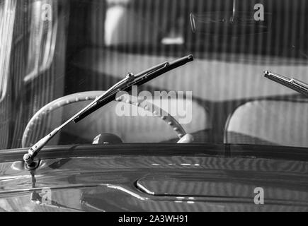 Il tergicristallo anteriore e il volante. Old timer dettagli auto. Close up foto in bianco e nero con morbida messa a fuoco selettiva Foto Stock