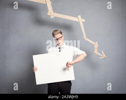Imprenditore infelice che mostra nel pannello anteriore del grafico decrescente. Foto Stock
