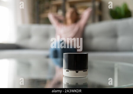 Portatile altoparlante wireless sul tavolo con la donna in un momento di relax a casa Foto Stock