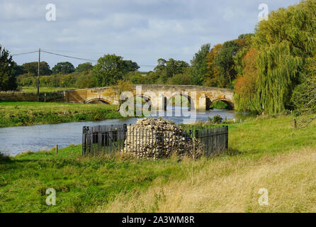 Ponte sul fiume Nene e l'ultimo pezzo di muratura originale sul sito del castello di Fotheringhay Foto Stock