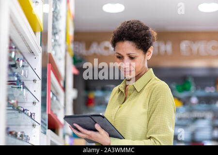 Proprietario di piccola impresa lavorando su tavoletta digitale in negozio Foto Stock