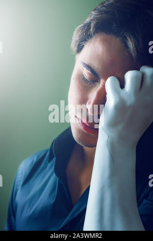 Ritratto di un giovane uomo che sostengono la sua testa su un braccio di pietra che sta cominciando a frantumare Foto Stock