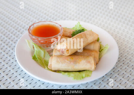 Rulli con riempimento e salsa piccante sul tavolo. Rotoli di frittelle con ripieno di carne servita ketchup salsa. Il cibo gustoso. Foto Stock