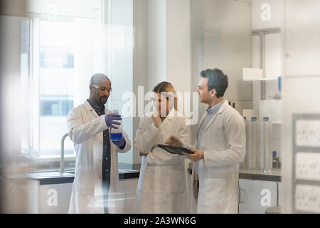 Team di scienziati a discutere di esperimento dati sulla tavoletta digitale Foto Stock