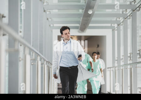 Ritratto di medico maschio a piedi attraverso ospedale Foto Stock