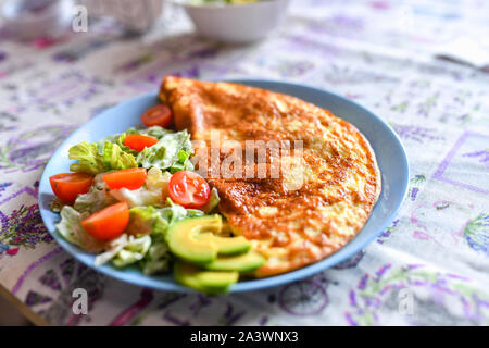 Uova fritte con le verdure. Su uno sfondo luminoso. la colazione per uno Foto Stock