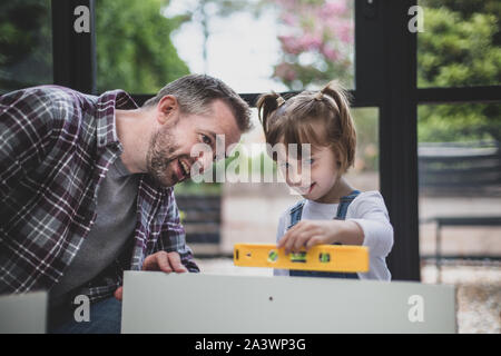 Padre Figlia di insegnamento come utilizzare una livella a bolla Foto Stock