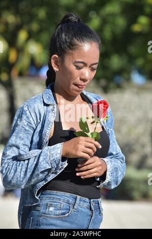 Impassibile attraente Asian femmina adulta con fiore rosa Foto Stock