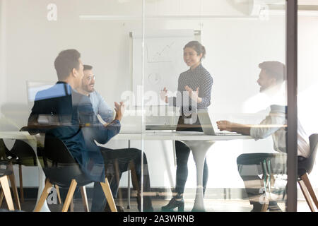 Sorridente indiano altoparlante femmina dare lavagna presentazione nella sala riunioni Foto Stock