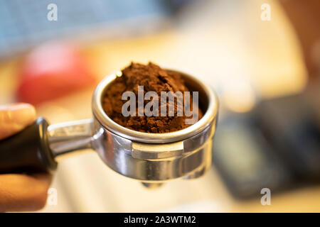 Passo dopo passo il caffè facenti parte tre. Il caffè è nel gruppo maniglia o portafilter in preparazione per la timbratura o premendo il caffè Foto Stock