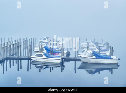 Nebbia di mattina su barche ormeggiate al fianco di un molo al Lago Derwentwater, Lake District, Cumbria, Inghilterra. Foto Stock