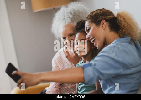 Tre generazioni della famiglia prendendo un selfie Foto Stock