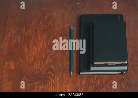 I notebook chiuso con disegno a matita su isolati sullo sfondo di legno Foto Stock