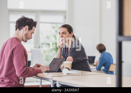 Donna ispanica lavorando in un coworking space Foto Stock