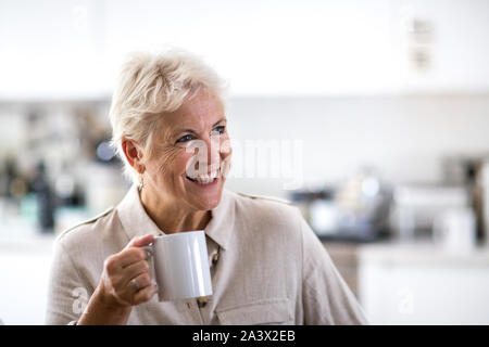 Adulto donna in conversazione tenendo una tazza di tè Foto Stock
