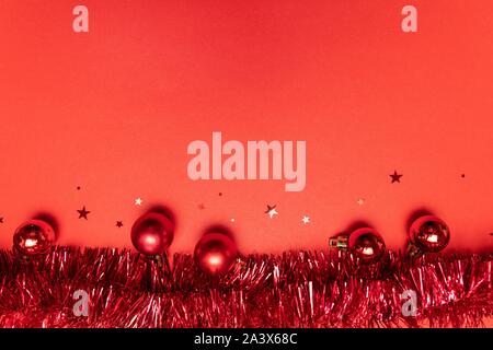 Natale e Anno Nuovo sfondo rosso con finitura lucida e opaca, sfere glitter stelle su uno sfondo di colore rosso. Appartamento laico, vista dall'alto, spazio di copia Foto Stock