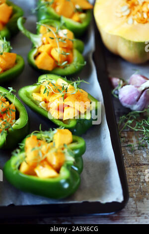 La paprica peperoni ripieni di zucca. Paprika cotti al forno con la zucca. Pranzo vegano. In autunno il cibo. Messa a fuoco selettiva. Macro. Foto Stock