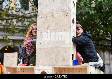 Londra, Regno Unito. Il 10 ottobre 2019. Gli attivisti fissato ad una struttura di legno in Trafalgar Square durante il giorno 4 di estinzione Rebellion cambiamenti climatici protesta nella capitale. Gli attivisti chiedono al governo di prendere provvedimenti immediati contro le conseguenze negative del cambiamento climatico. Credito: Stephen Chung / Alamy Live News Foto Stock