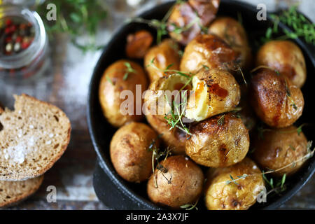 Patate al forno in una scorza in un cast di padella di ferro. Patate rustiche. Messa a fuoco selettiva. Macro. Foto Stock