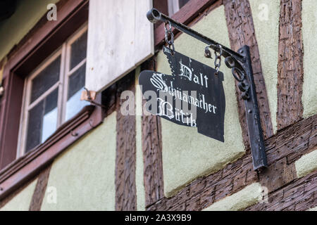 D'alt Schuamacher Butik, un vecchio calzolai o calzolai shop segno su una vecchia metà timered edificio in Eguisheim Alsace Francia Foto Stock