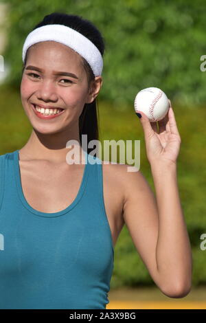 Sportivo femminile di minoranza giocatore di baseball sorridente Foto Stock