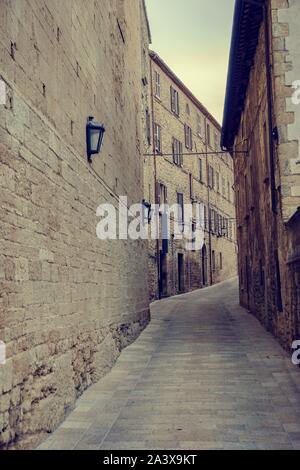 Foto verticale in antica strada di Urbino città d'Italia. Entrambe le case e la pavimentazione è stata creata dalla pietra. La città è sulla lista dell'Unesco. Il cielo è Foto Stock