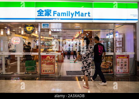 I pedoni a piedi passato un giapponese convenience store catena di franchising, FamilyMart store in Shenzhen. Foto Stock