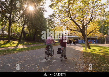 Amsterdam, Paesi Bassi, ottobre 11, 2018: Coppia senior di andare in bicicletta nel Parco di Vondel di sunny ottobre sera Foto Stock