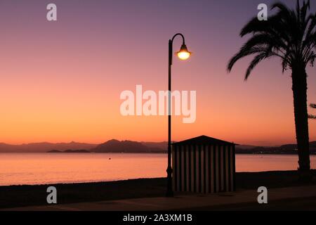 Striping capanna sulla spiaggia al tramonto sulla spiaggia di La Azohia village, Cartagena, Murcia, Spagna. Foto Stock