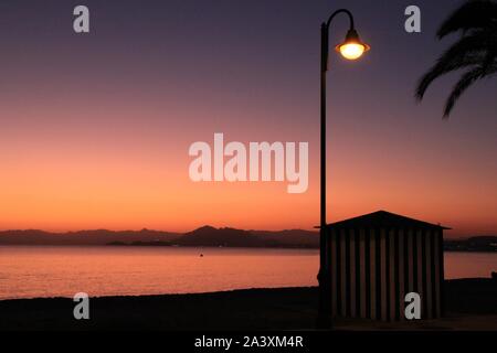 Striping capanna sulla spiaggia al tramonto sulla spiaggia di La Azohia village, Cartagena, Murcia, Spagna. Foto Stock