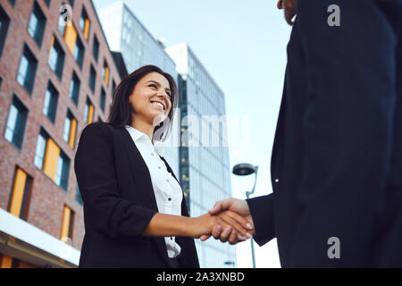 Business di handshake. Imprenditore e business donna fanno strette di mano mentre in piedi all'aperto Foto Stock