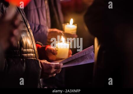 Monaco di Baviera, Germania. 10 ottobre, 2019. Una candela sorretta da un partecipante di una preghiera per la pace la raccolta presso il Judische Gemeinde (Comunità Ebraica) di Monaco di Baviera, Germania rispondere al terrore attentato a Halle, Germania che è costato la vita di due persone. Centinaia assemblati per una preghiera interreligiosa contro l odio e l ondata di violenza che si sta diffondendo in tutto il mondo come il populismo di destra e di terrore sorge. Credito: Sachelle Babbar/ZUMA filo/Alamy Live News Foto Stock