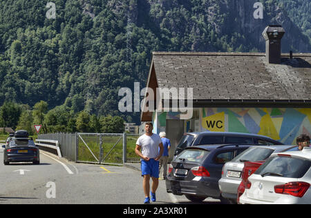 La Svizzera, Agosto 2019. Autostrada per la Germania, una zona di riposo con servizi igienici pubblici costruito in una casa colorati. Il parcheggiato e occupato di auto di persone che fanno uso di th Foto Stock