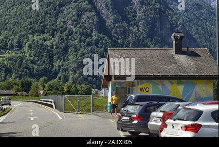 La Svizzera, Agosto 2019. Autostrada per la Germania, una zona di riposo con servizi igienici pubblici costruito in una casa colorati. Il parcheggiato e occupato di auto di persone che fanno uso di th Foto Stock