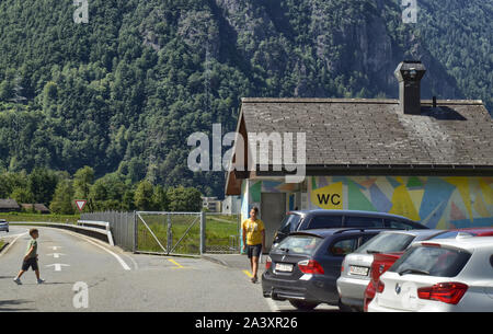 La Svizzera, Agosto 2019. Autostrada per la Germania, una zona di riposo con servizi igienici pubblici costruito in una casa colorati. Il parcheggiato e occupato di auto di persone che fanno uso di th Foto Stock