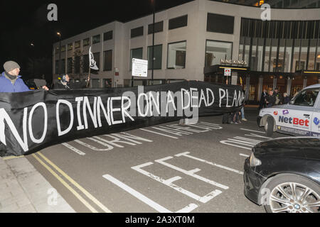 Londra, UK, 10 ott 2019. I manifestanti bloccano la strada all'esterno dell'hotel con un 'No la cena su un pianeta morto' banner, riferendosi alla cena annuale manifestazione all'interno. Estinzione della ribellione manifestanti da Londra XR gruppi, comprese le XR batteristi, protesta al di fuori della British Plastics Federation (BPF) cena annuale presso il Royal Lancaster Hotel questa sera. L'evento è un'industria annuale e l'evento di networking per il settore della plastica. Molti dei partecipanti di interagire e chattare con i manifestanti in questa occasione. Credito: Imageplotter/Alamy Live News Foto Stock