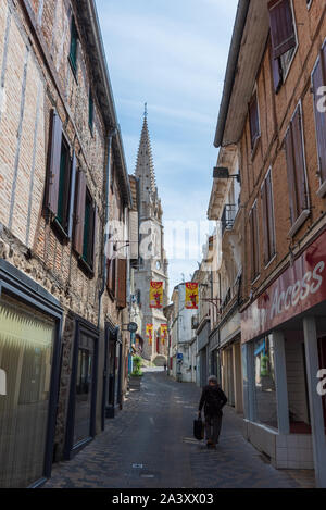 Lone persona a camminare su una strada deserta nella cittadina francese di Parthenay Foto Stock